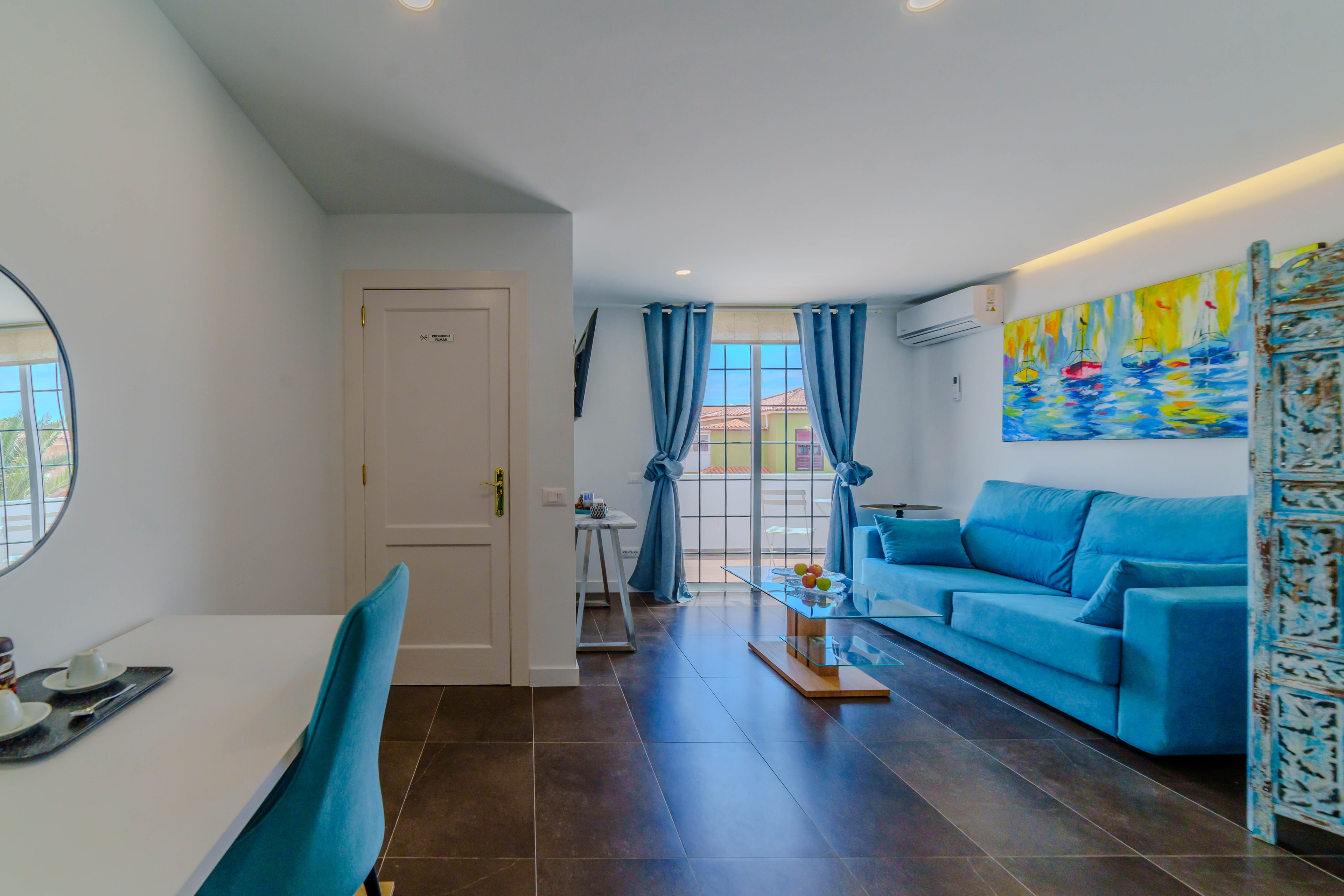 Suite con salón propio, sofá y puertas de balcón